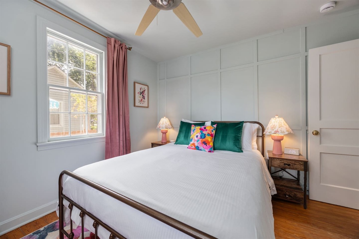 The second bedroom includes a Queen bed, smart TV, and lovely natural light. Both bedrooms have a window to the backyard.