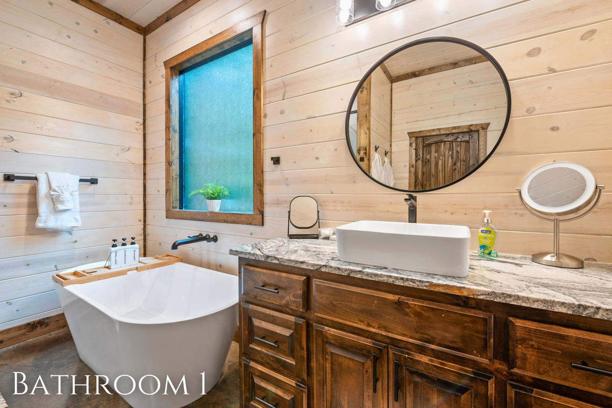 A luxurious bathroom with a deep soaking tub and wood accents, perfect for moments of quiet and relaxation.