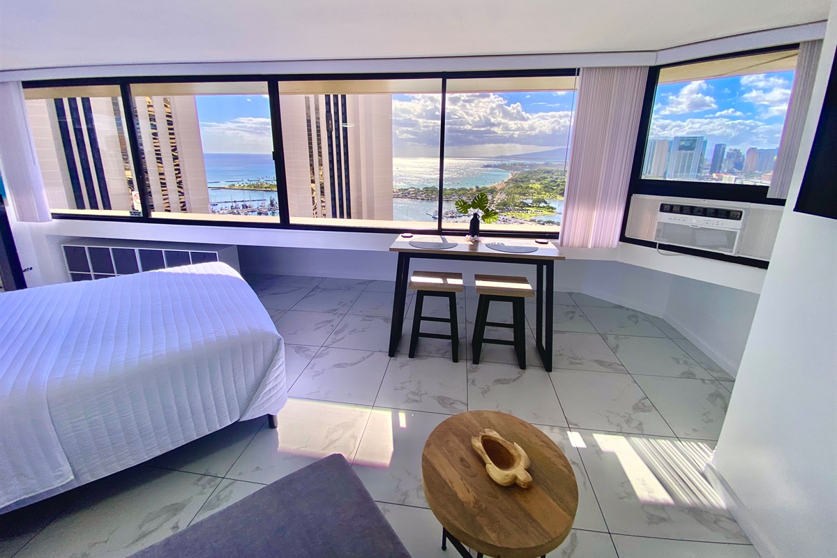 Wake up to panoramic ocean and harbor views stretching across the Honolulu coastline. This elegant Waikīkī studio offers floor-to-ceiling windows, modern finishes, and the perfect space to enjoy breakfast with a view of paradise.