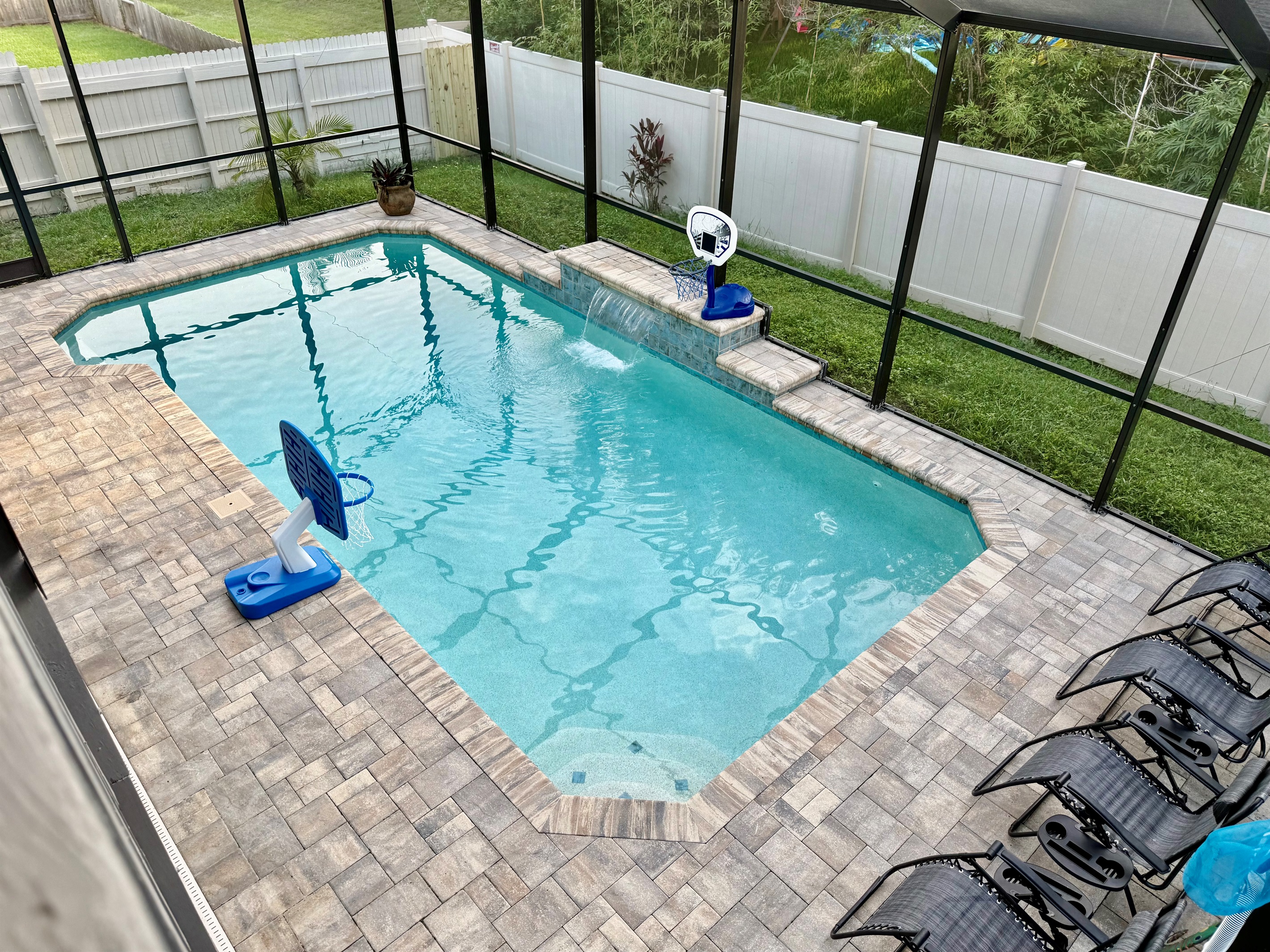 Enjoy the outdoors without the hassle—this entire pool area is enclosed with a full-screen structure, keeping bugs and debris at bay while still letting in plenty of sunlight and fresh air.