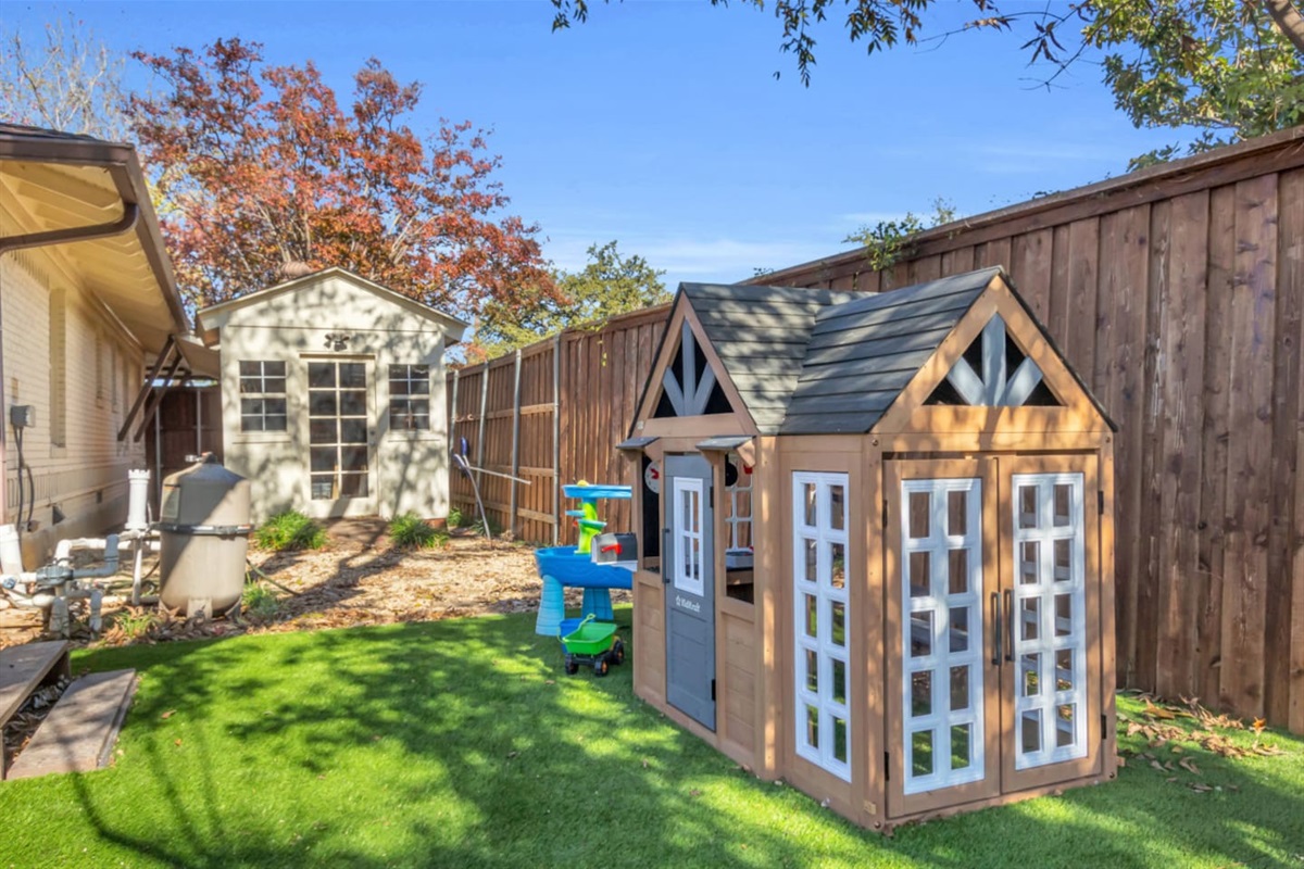 Kid-approved hideaway featuring a spacious playhouse with double doors and lots of natural light—an inviting retreat for imaginative play.