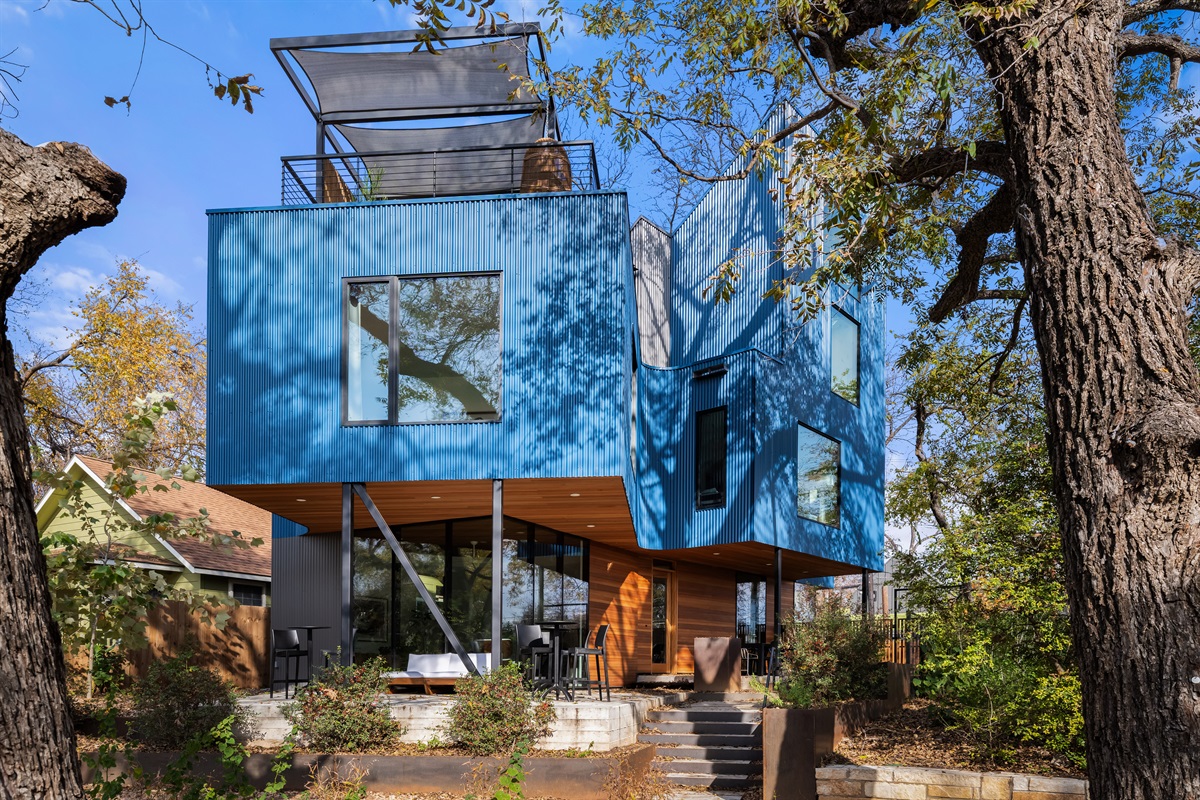 Striking modern exterior tucked among mature trees—an architectural gem that blends nature and design.