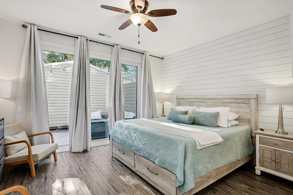 Main-level king suite with private patio access — sleep in, you're on beach time