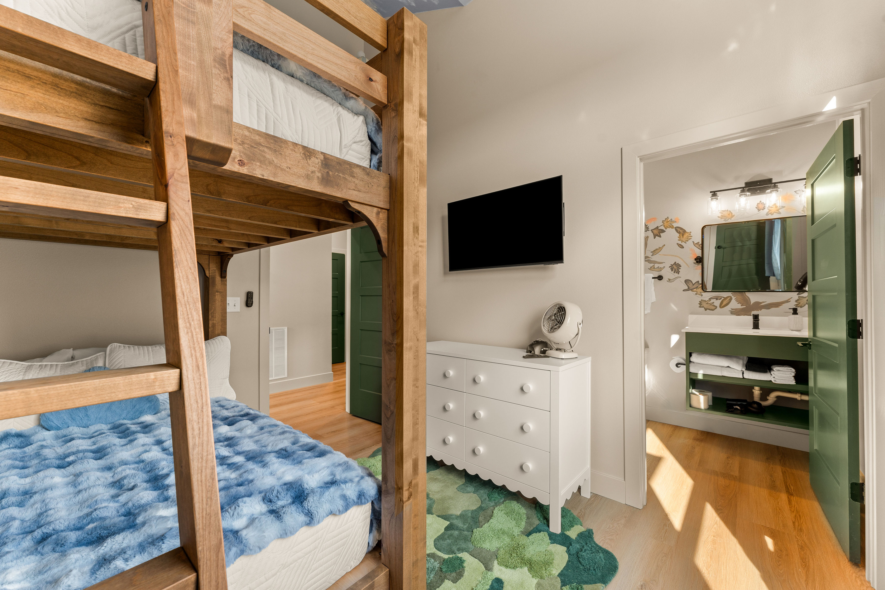 The whimsical bunk room includes its own nearby bath, making this a convenient setup for kids, teens, or families sharing the space.