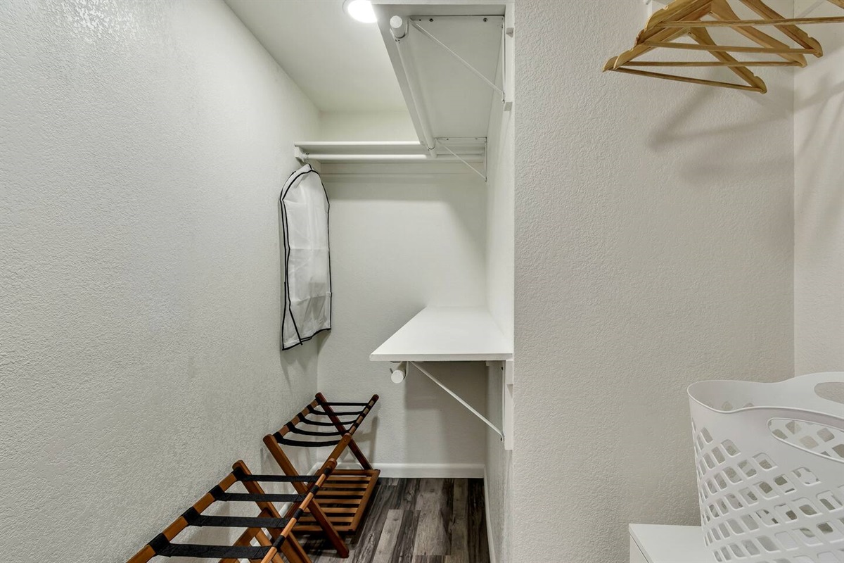 Master closet with suitcase storage.