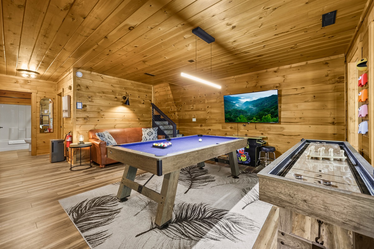 Game room downstairs has a pool table, shuffleboard, and sit down Pac Man arcade. Cornhole boards wait for you outside to play.