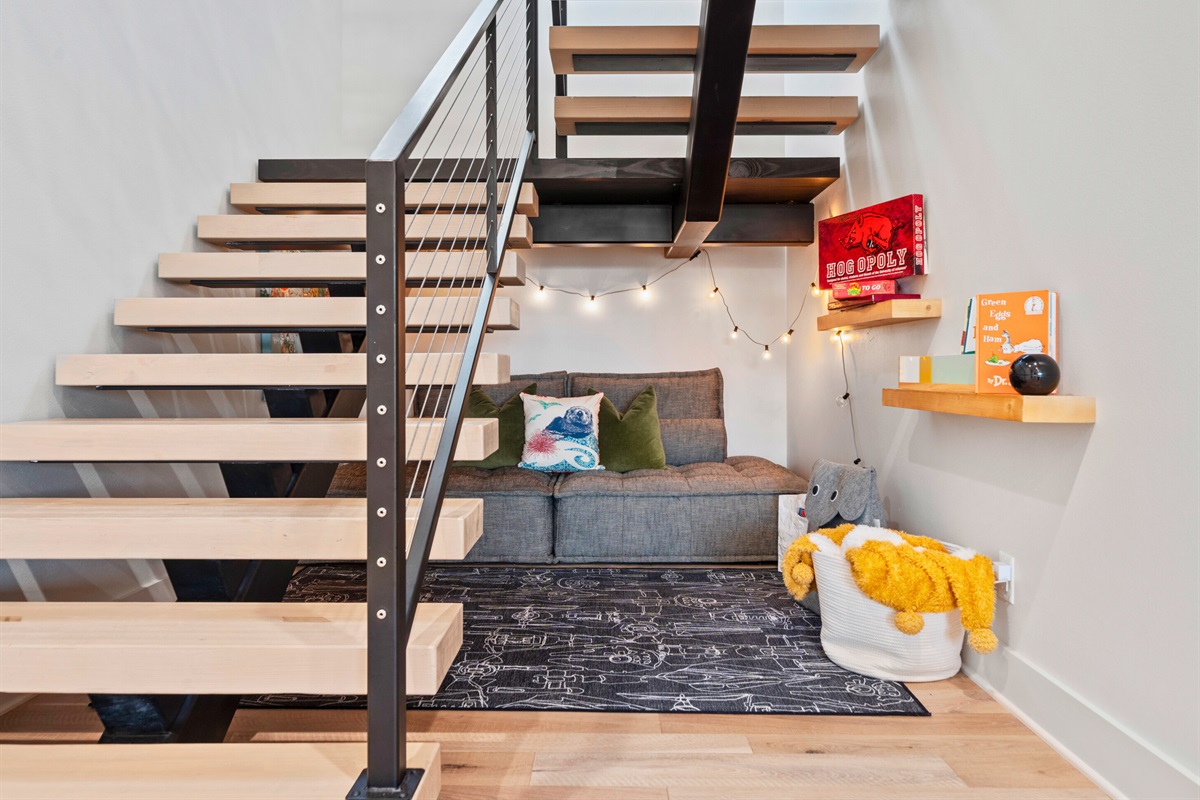 A charming and comfortable nook that makes clever use of space under the stairs, perfect for relaxation.