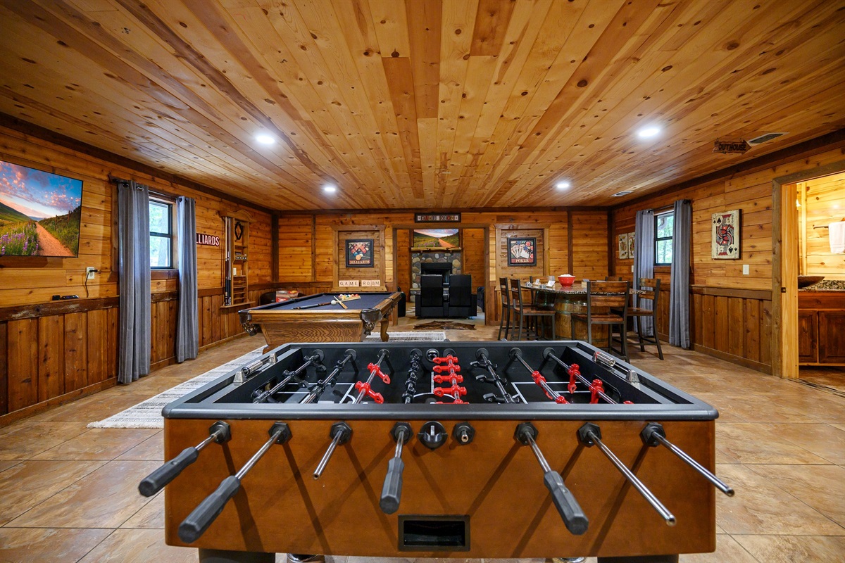 This game room has it all. Foosball, pool table, Pac-man arcade and table for games.