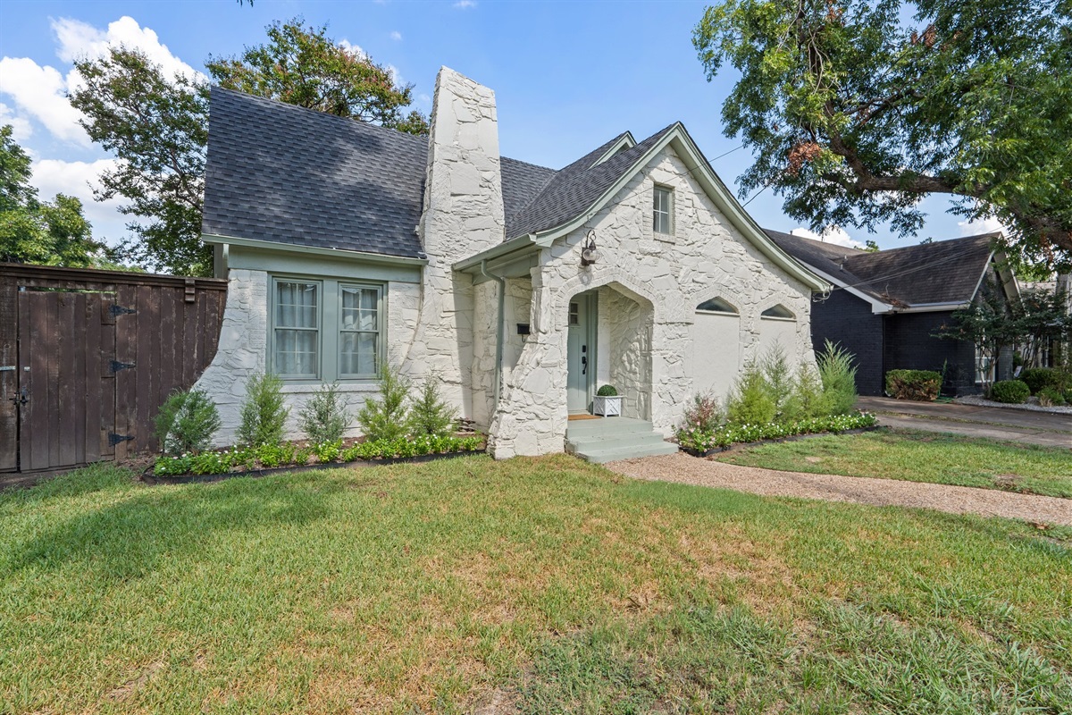 Classic 1929 stone facade with arched windows and tree-lined street. Charming curb appeal in one of Dallas's most storied residential corridors, minutes from Love Field.
