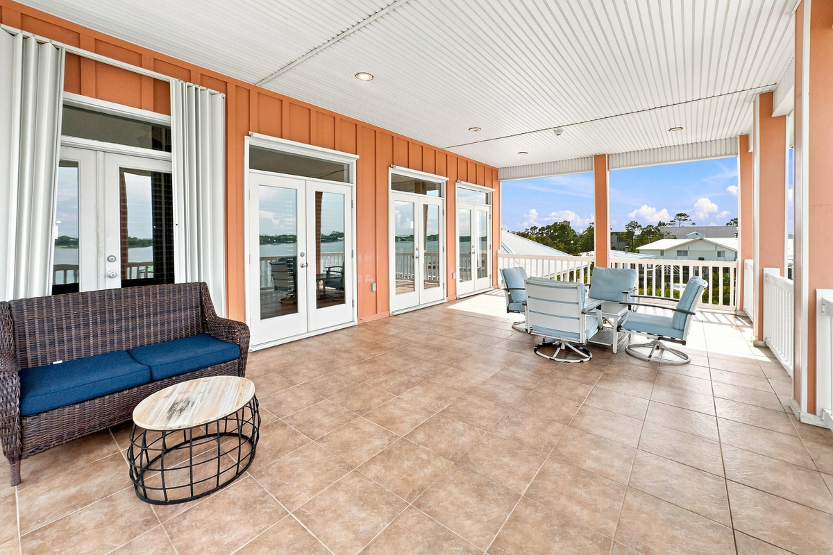 Bright sunroom porch with lounge seating and lagoon views