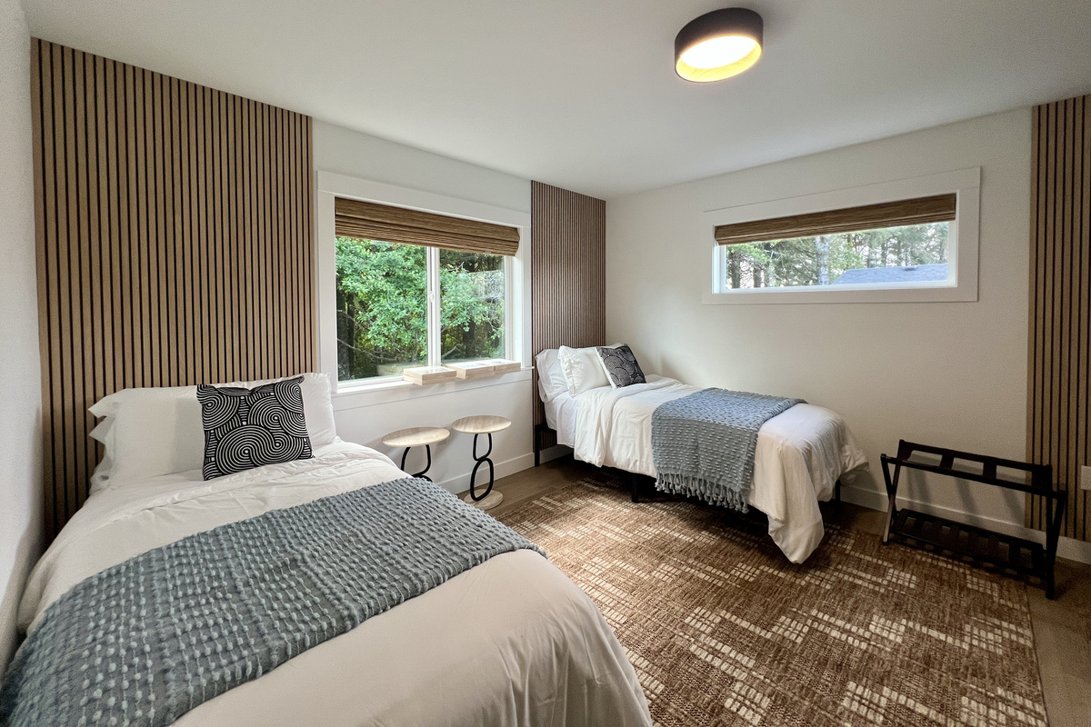 Another bedroom with two twin beds and a chic wood-slat accent wall — the twins can also be joined together to make a king.