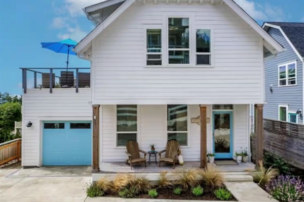 Coastal elegance at Vista Blue — a crisp white facade with serene blue accents, a private driveway, and welcoming outdoor spaces.