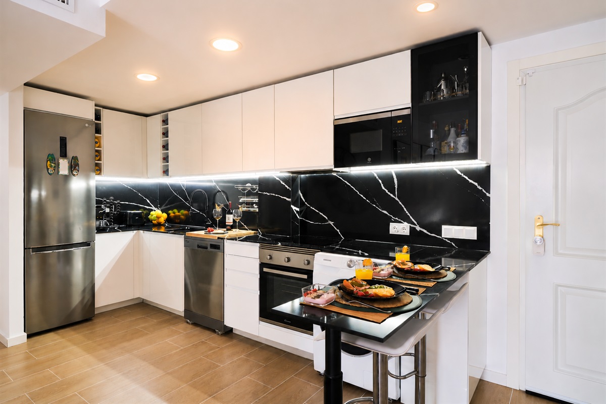 Modern, fully equipped kitchen with high-end appliances, elegant black quartz backsplash, and everything you need for a comfortable stay.