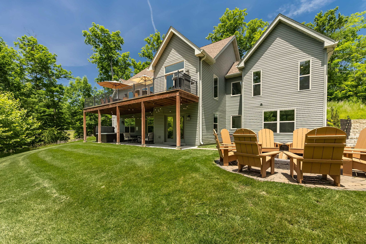 The expansive lawn backs to peaceful woods for added privacy.