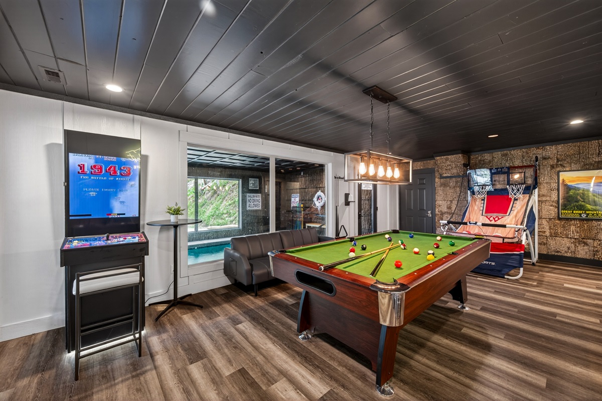 Pool table, video games and basketball. Indoor swimming pool room (self-locking door and alarm) on other side of glass from game room.
