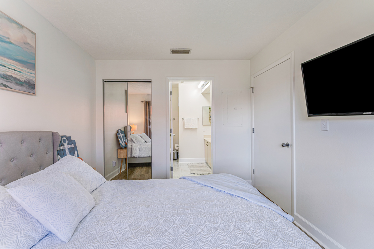 Relax in the comfort of the primary bedroom, featuring a private ensuite bathroom and direct access to the balcony. It's a peaceful retreat to recharge after a day in the sun.

