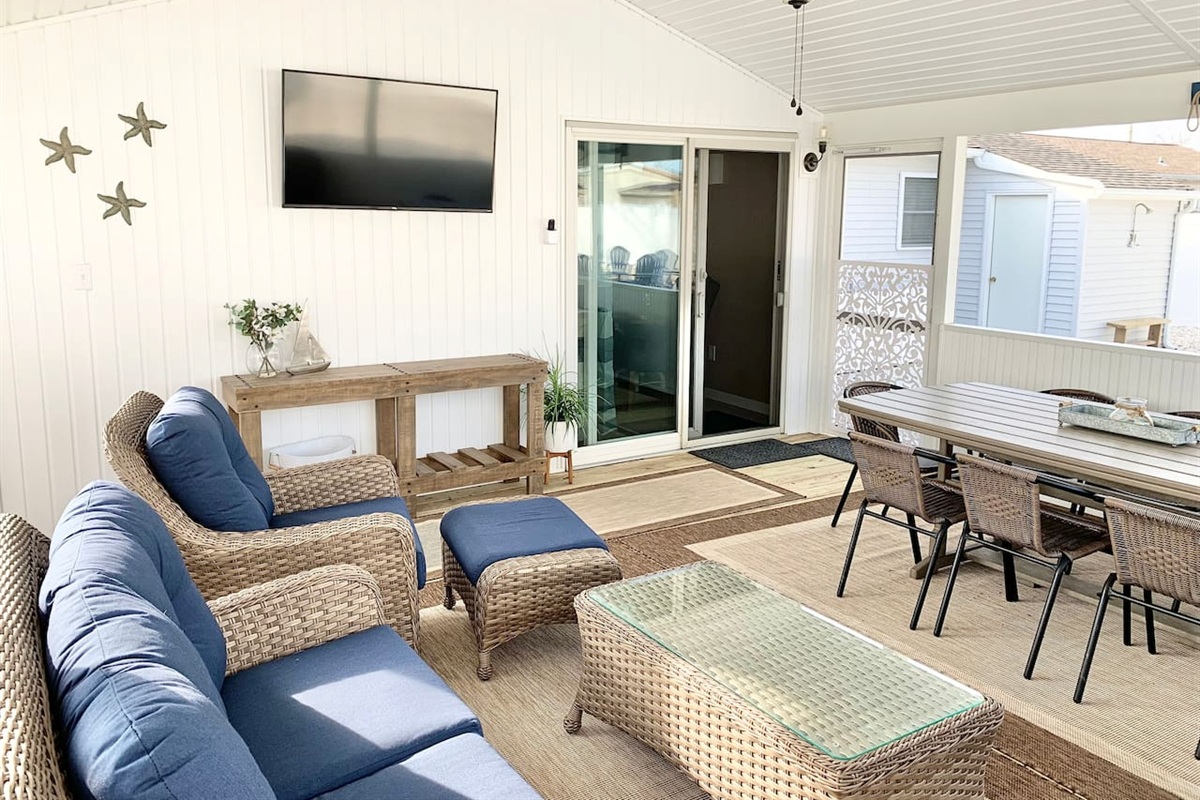 Relax in our bright screened in porch, featuring comfortable wicker seating, a flat-screen TV, and a full dining table. Perfect for morning coffee or evening games, this airy space offers a seamless blend of indoor comfort and outdoor vibes.