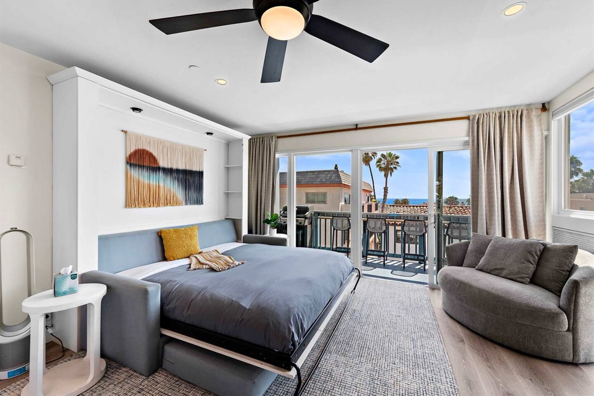 Living room with sofa-murphy bed ready for use.  This bed is every bit as comfortable as a traditional bed with a premium mattress. This King murphy bed enables this one-bedroom condo to accommodate up to four people comfortably.