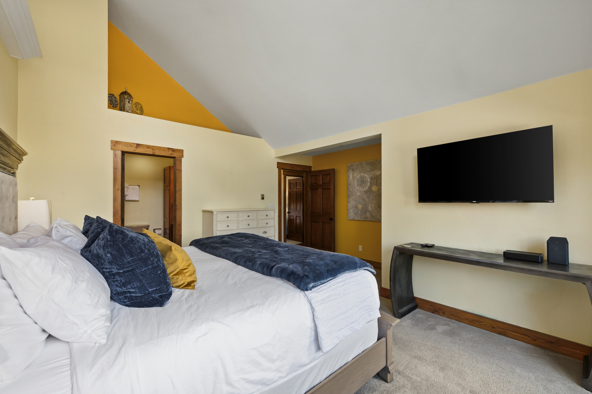 Primary bedroom with brand new large-screen tv and attached full bathroom. 