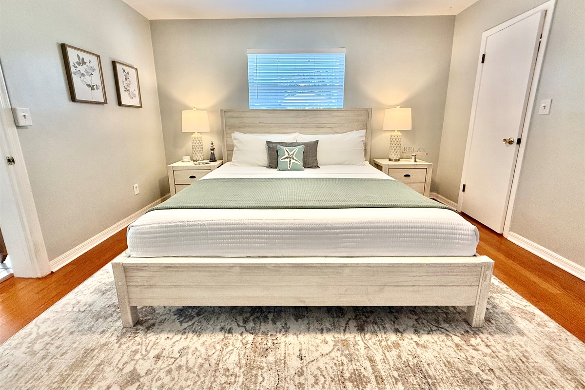 Coastal elegance meets comfort in this serene master suite with a king bed, soft textures, and soothing tones.