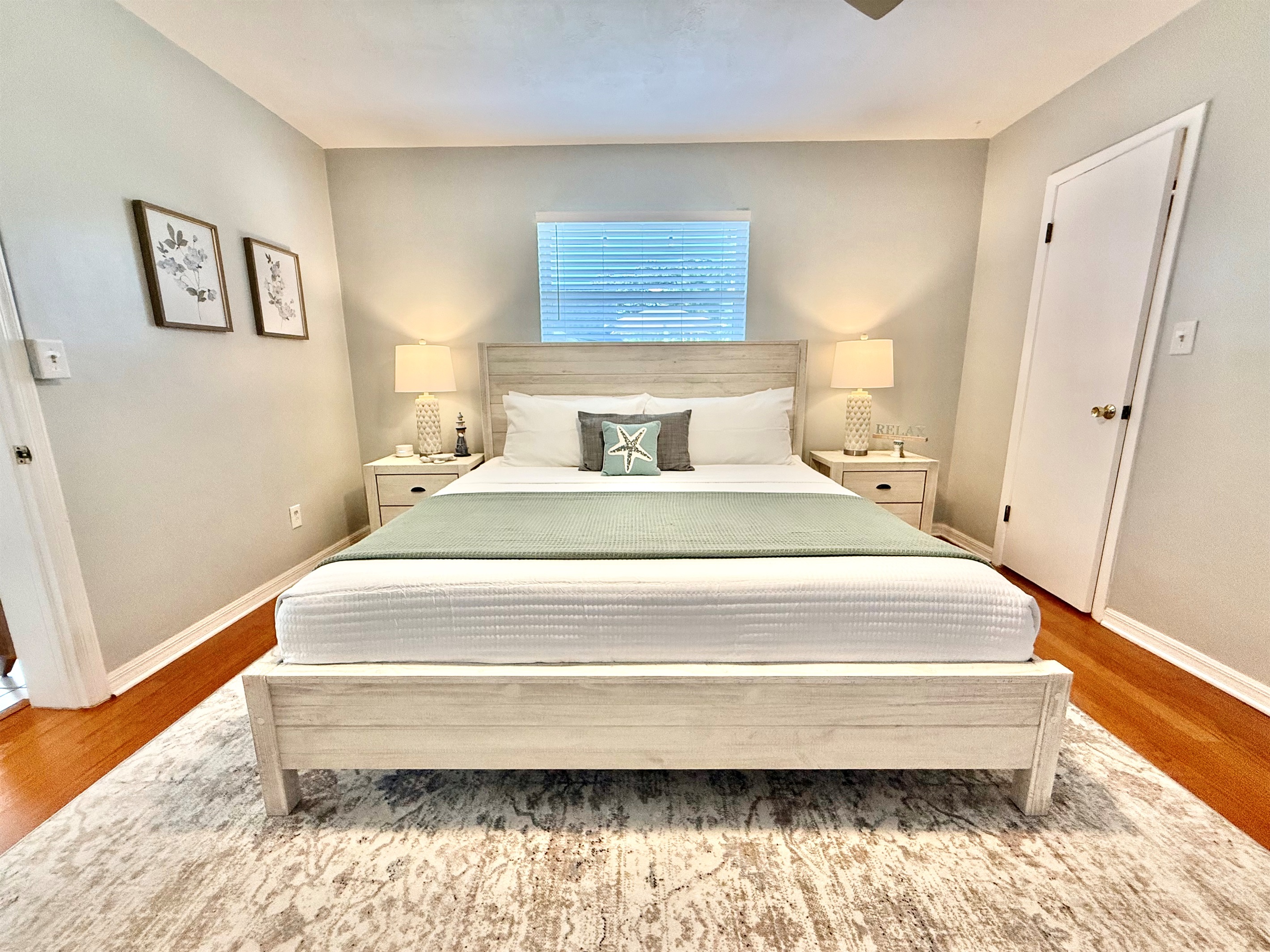 Coastal elegance meets comfort in this serene master suite with a king bed, soft textures, and soothing tones.