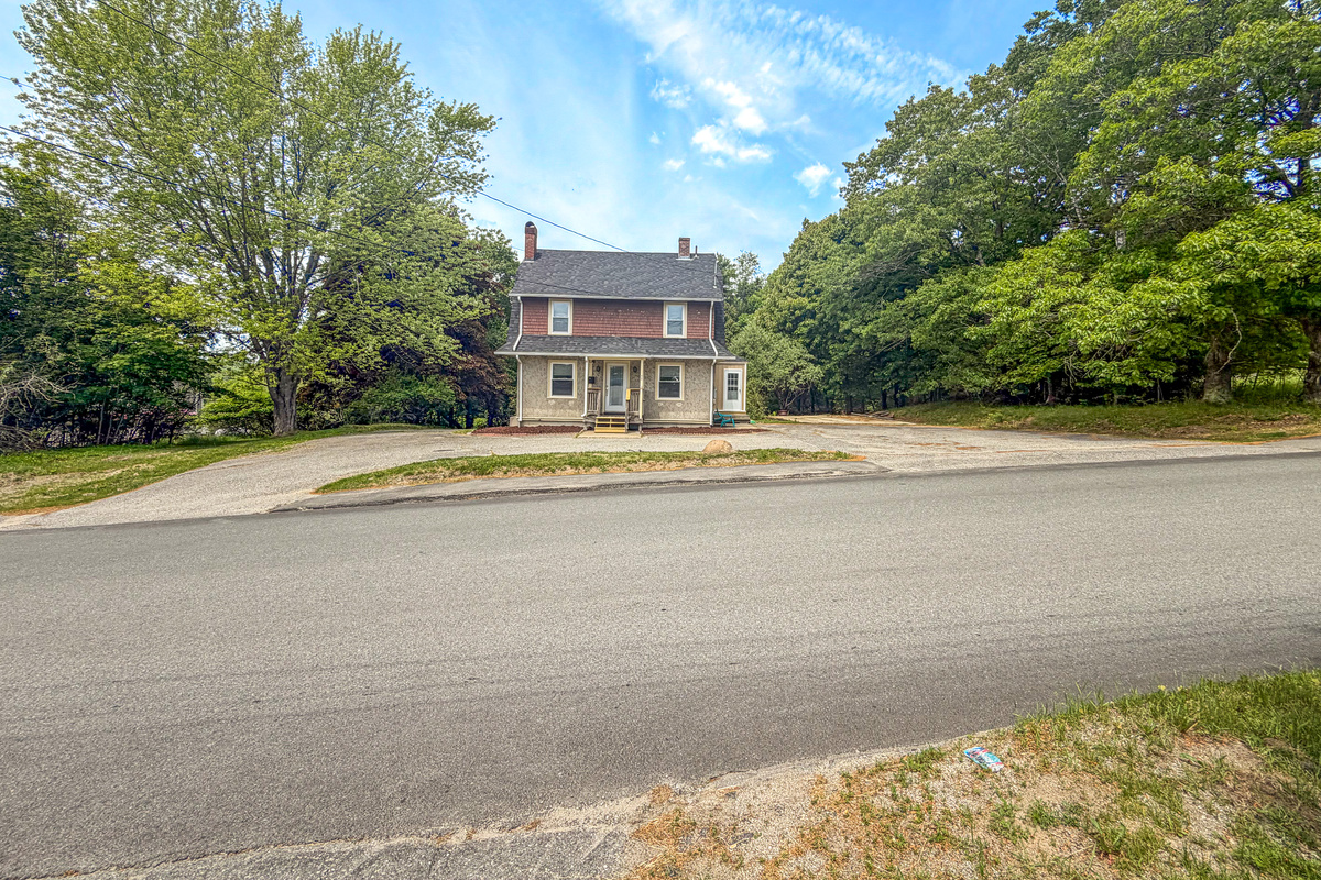 Your arrival experience begins with an abundance of open space. This wide exterior view highlights the wrap-around driveway and massive paved lot, offering effortless turnaround space for large trucks, boat trailers, and your entire group's vehicles.