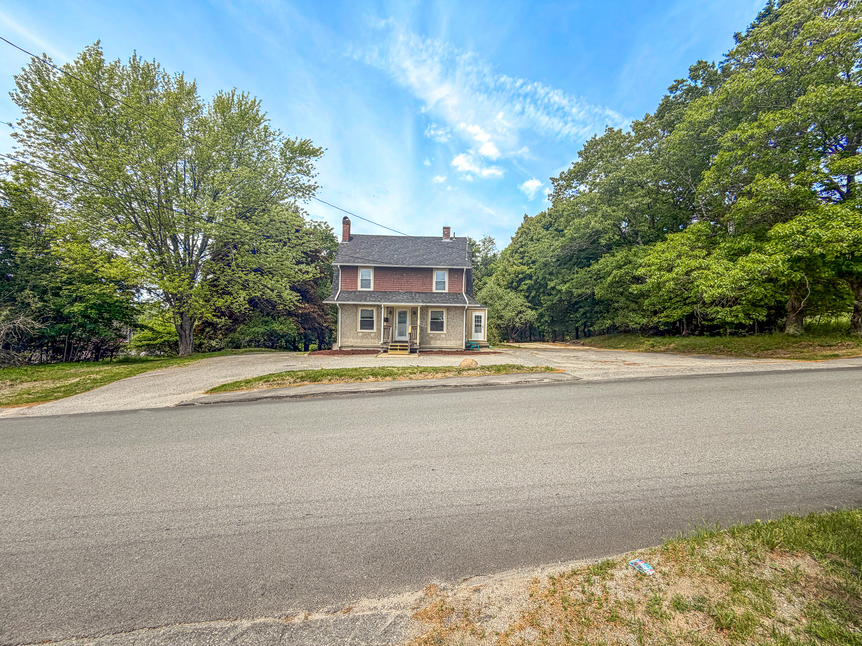 Your arrival experience begins with an abundance of open space. This wide exterior view highlights the wrap-around driveway and massive paved lot, offering effortless turnaround space for large trucks, boat trailers, and your entire group's vehicles.