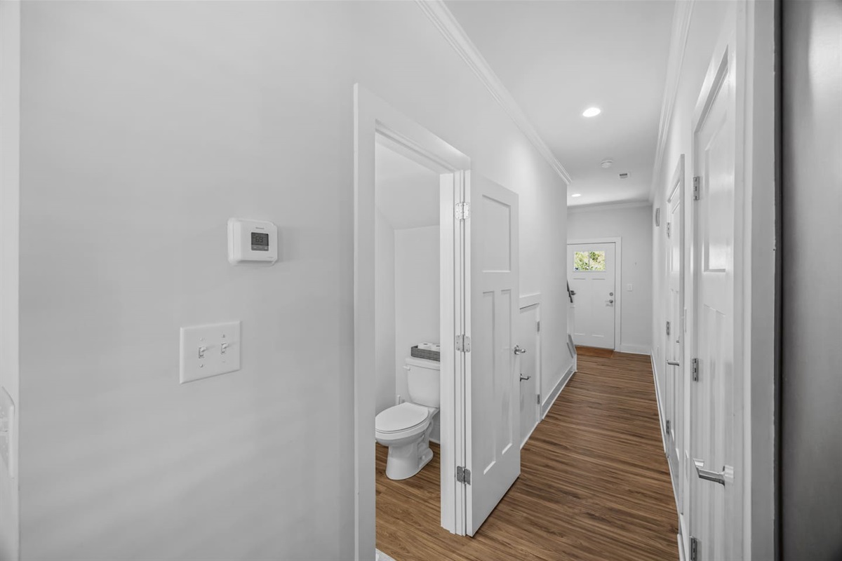 Bright hallway with stylish flooring, access to half bath, and a direct path to living spaces.