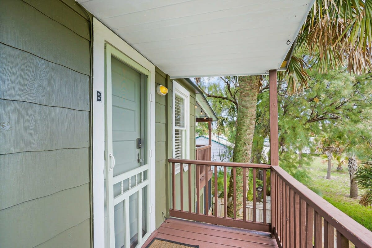 The covered walkway runs the full length of the upstairs, wrapping the apartment in shade and green. A small thing, perhaps, but it is exactly the sort of detail that makes a place feel properly lived in and loved.