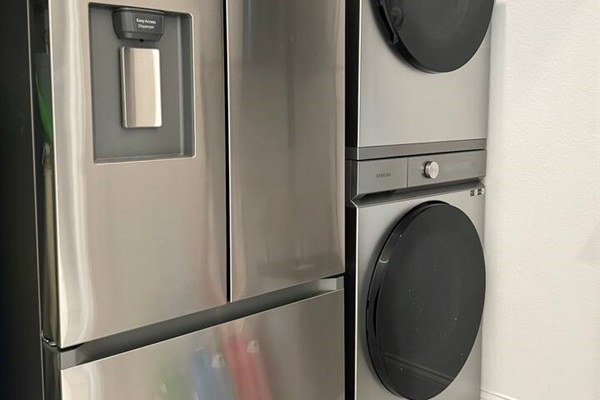 Laundry room has a stackable washer and dryer. There is even a second refrigerator with freezer for drinks in the laundry room. 