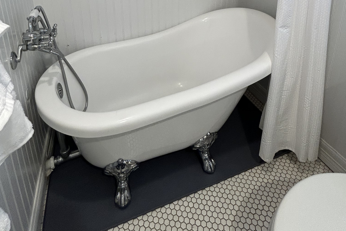 King Suite Ensuite Bathroom (Ground Level) features a charming clawfoot soaking tub and tranquil spa-like ambiance, creating the perfect retreat to relax and unwind after a day of island adventures.
