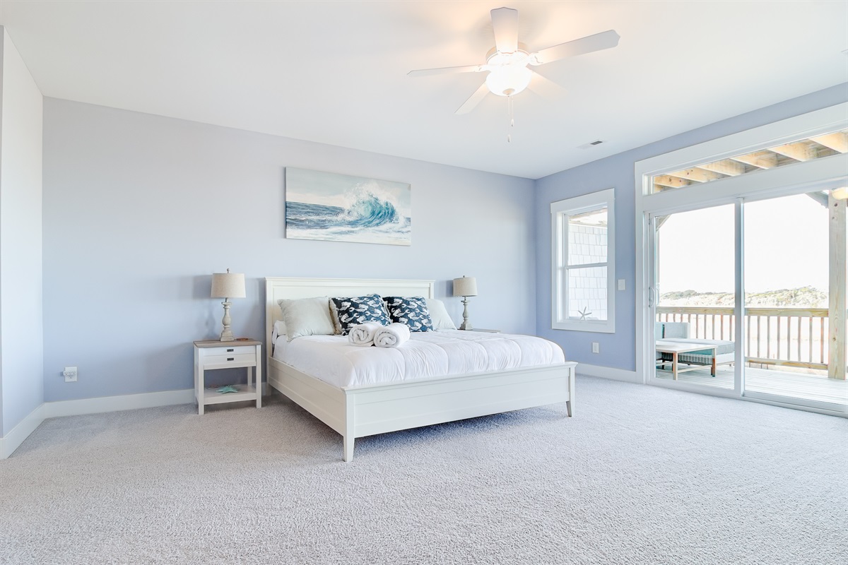 A spacious coastal retreat with a King bed, soft carpet, and direct access to the private balcony for fresh air and views