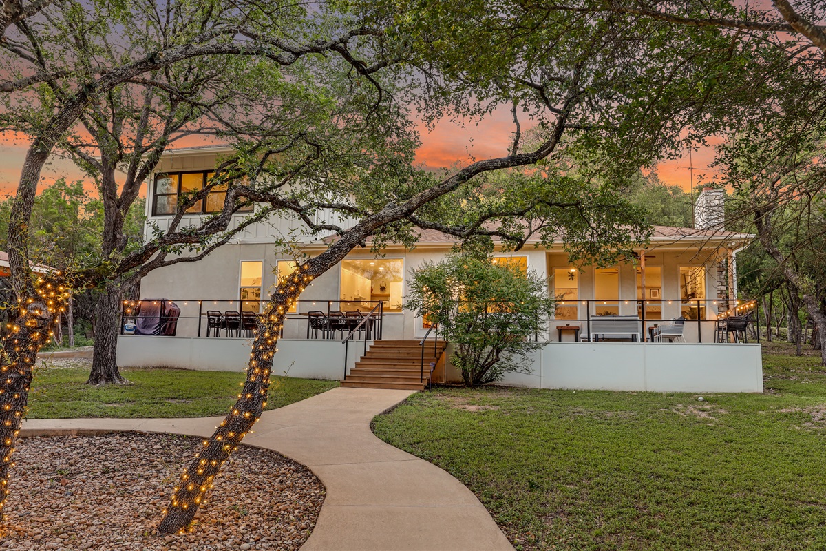 Spacious and inviting, this backyard oasis features a wide open lawn, mature trees, and a beautifully lit patio — perfect for outdoor dining or sunset gatherings with family and friends.