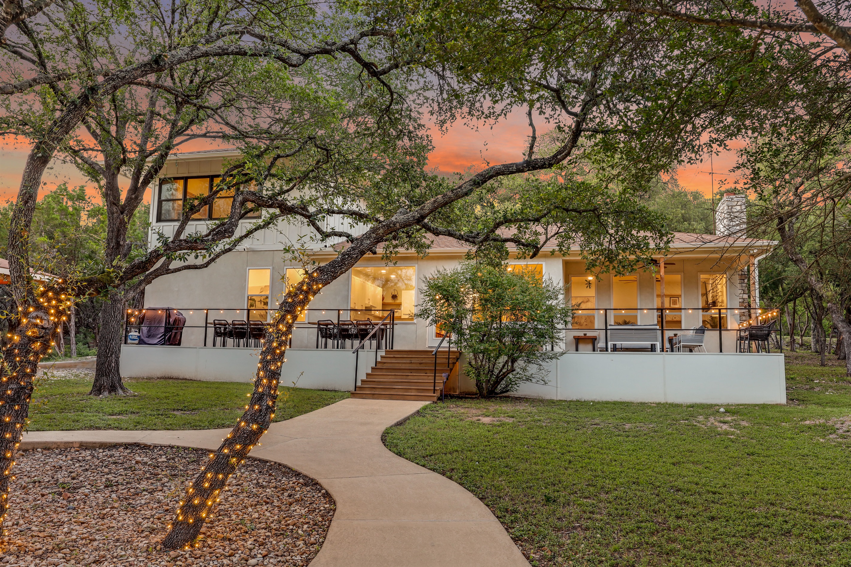 Spacious and inviting, this backyard oasis features a wide open lawn, mature trees, and a beautifully lit patio — perfect for outdoor dining or sunset gatherings with family and friends.