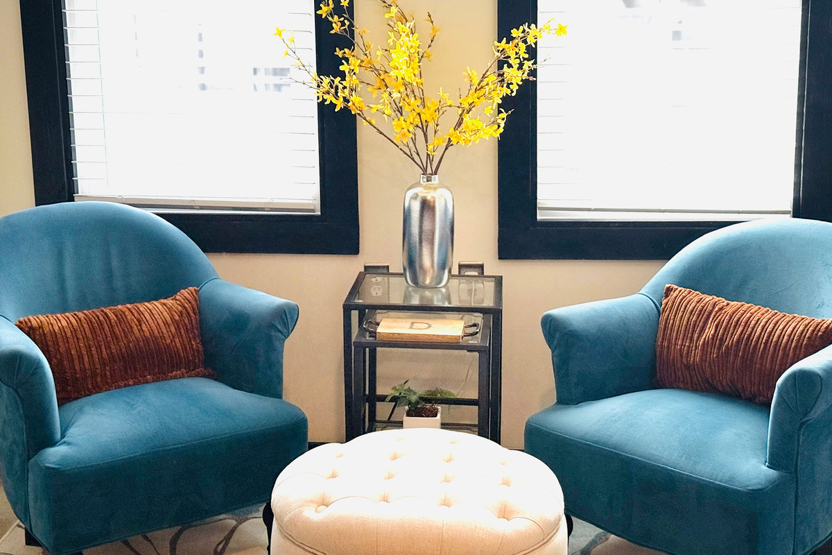 Two upholstered chairs create a comfortable conversation spot near the kitchen.