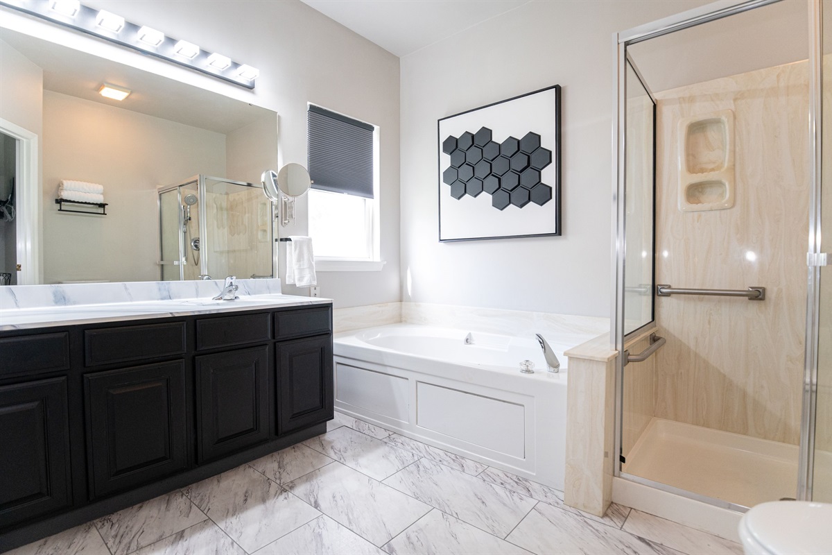 This main-level ensuite bathroom features a full tub/shower combo and fresh, modern finishes to start your day right.