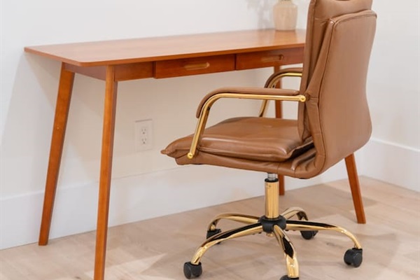 Dedicated workspace with sleek desk, leather chair, and mirror — perfect for remote work or getting ready.