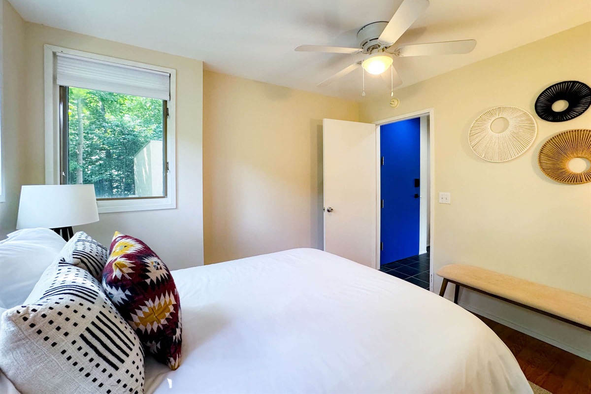 The main level bedroom features a comfy queen size bed and just inside of the entry door hallway.