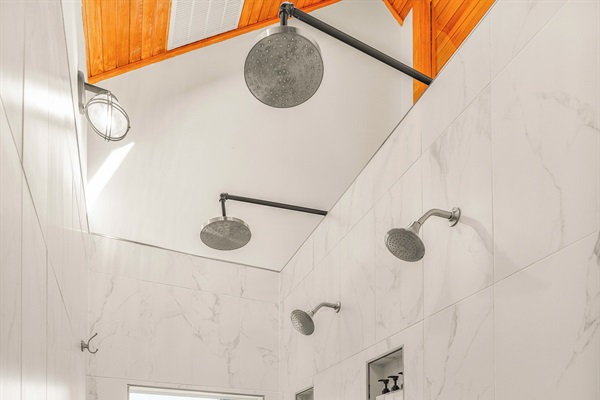 Oversized shower with side-by-side shower head sets and dual controls
