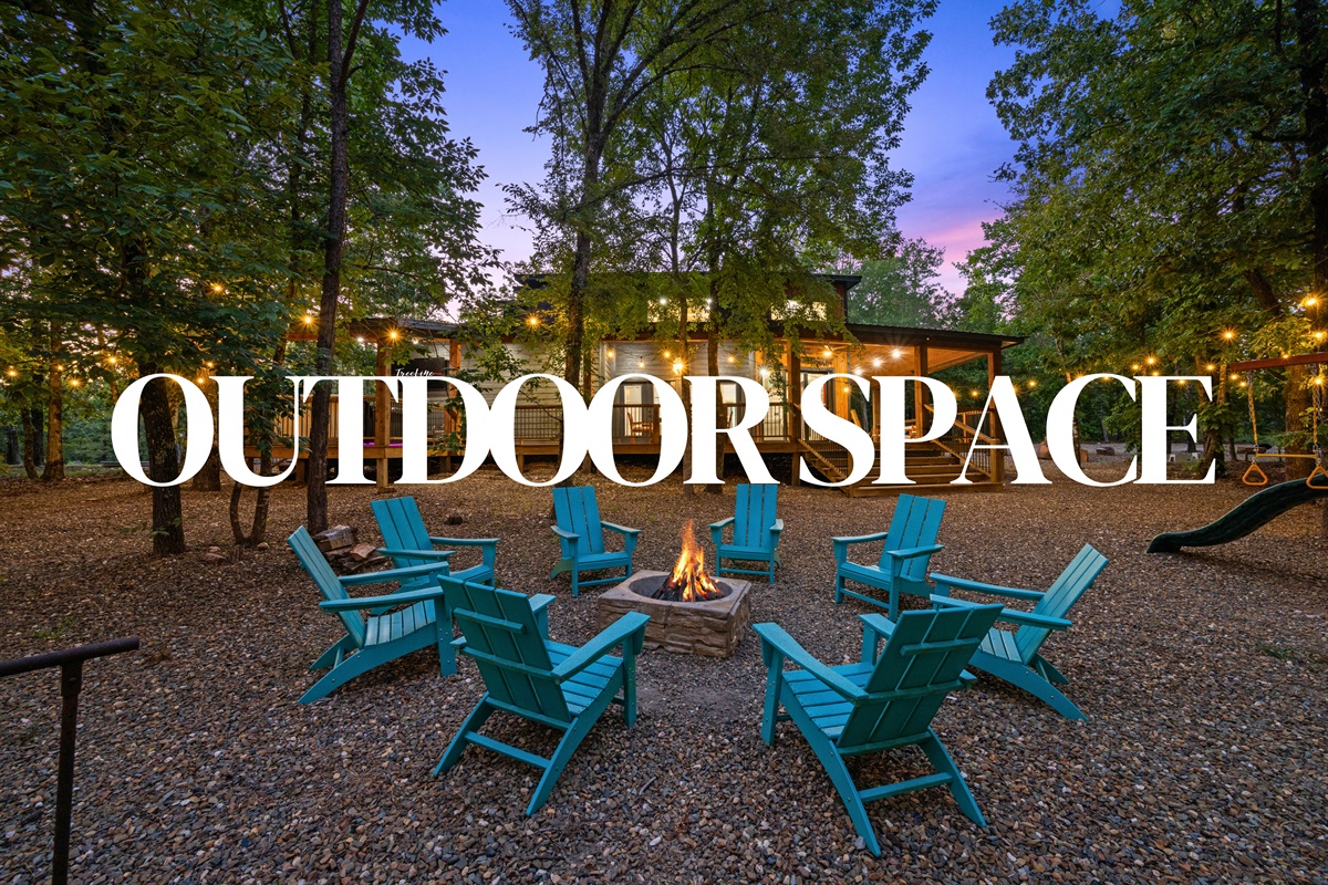 Expansive outdoor area with a fire pit and string lights under the trees.