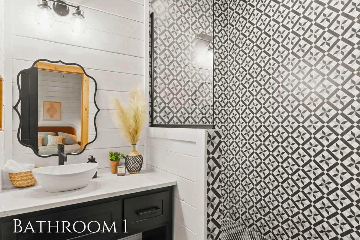 This bathroom strikes a captivating balance between bold patterns and rustic aesthetics.