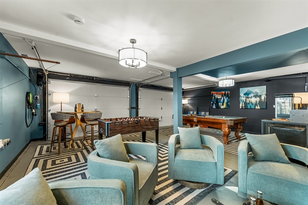 🎱🎮 Spacious game room with a pool table, foosball ⚽️, comfy lounge chairs 🛋️, and a high-top hangout spot 🍻—perfect for tournaments and late-night laughs ✨