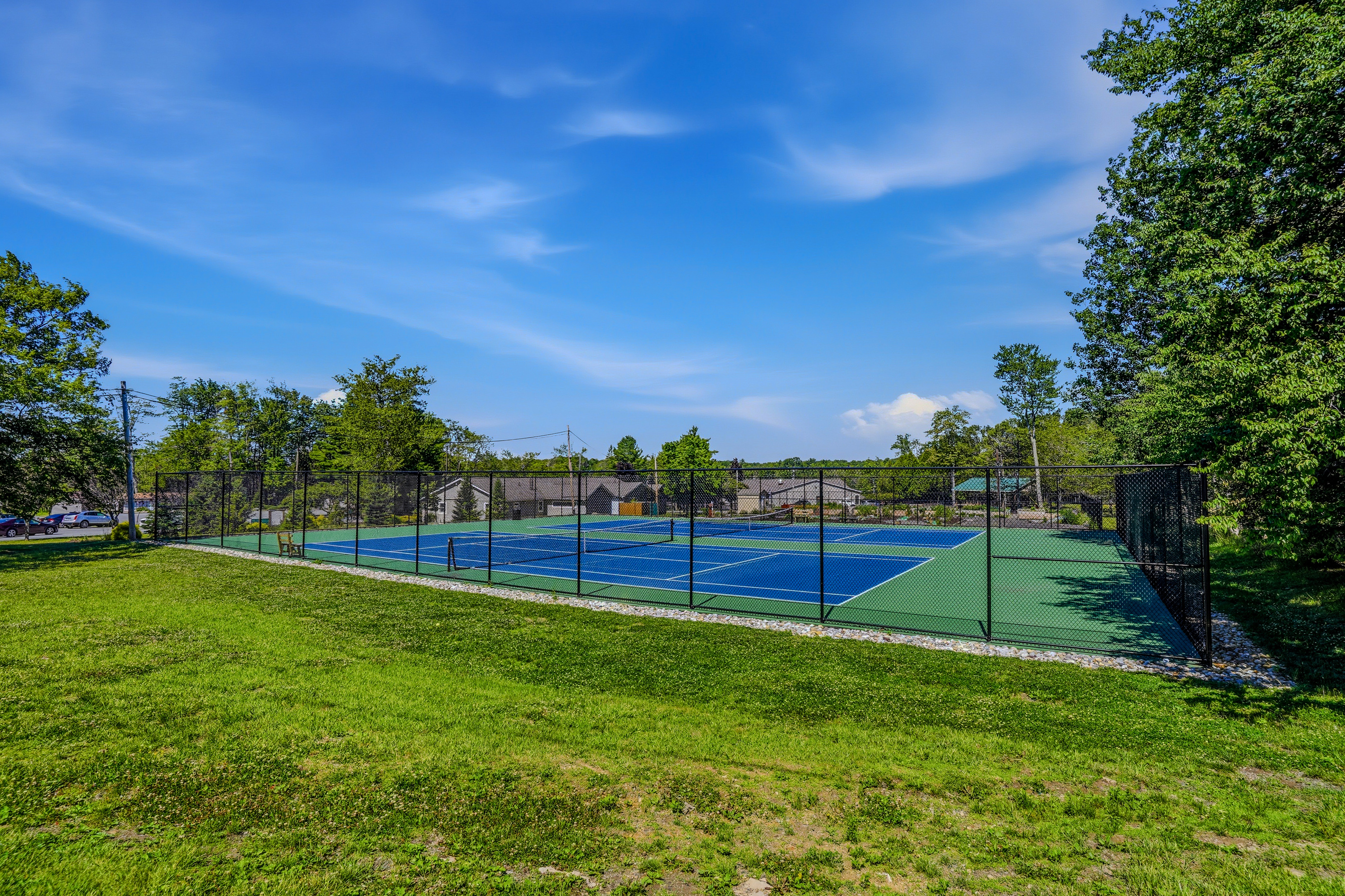 Community sports court — tennis and pickleball with fenced enclosure