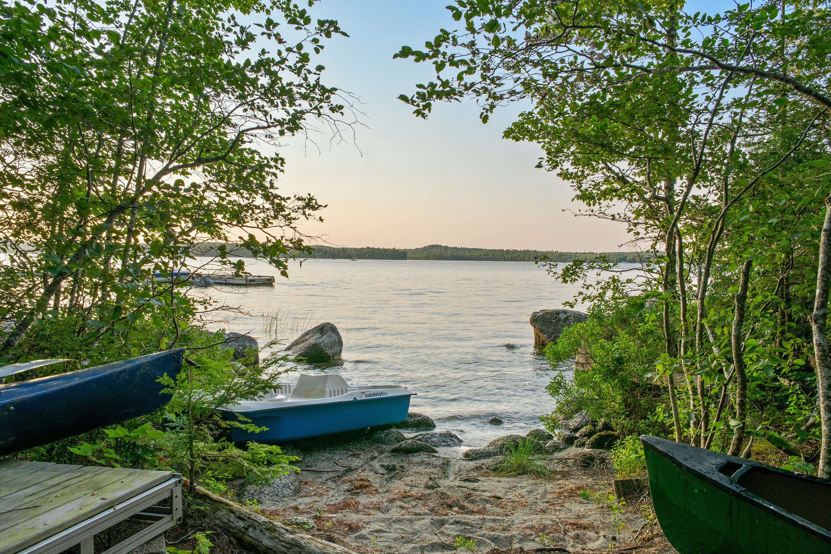 The beachy water entry at the end of the trailer path at Loonrise Point! Soft sandy shore leads into shallow Beech Hill Pond with complimentary paddle boat, canoe, and kayaks. Easy wade-in swimming and launching spot in Otis, ME.