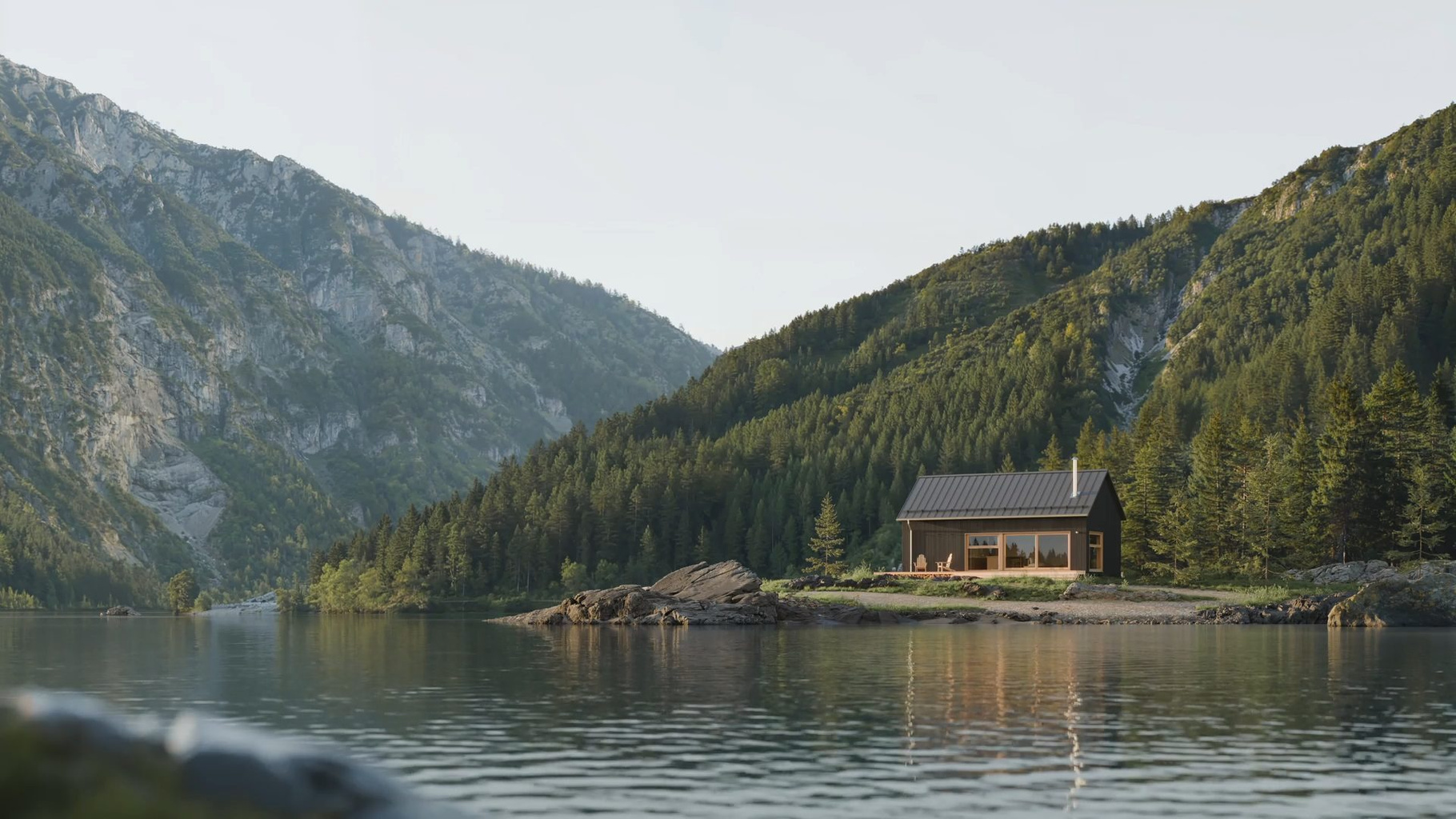 Chalet au bord d’un lac, entouré de montagnes