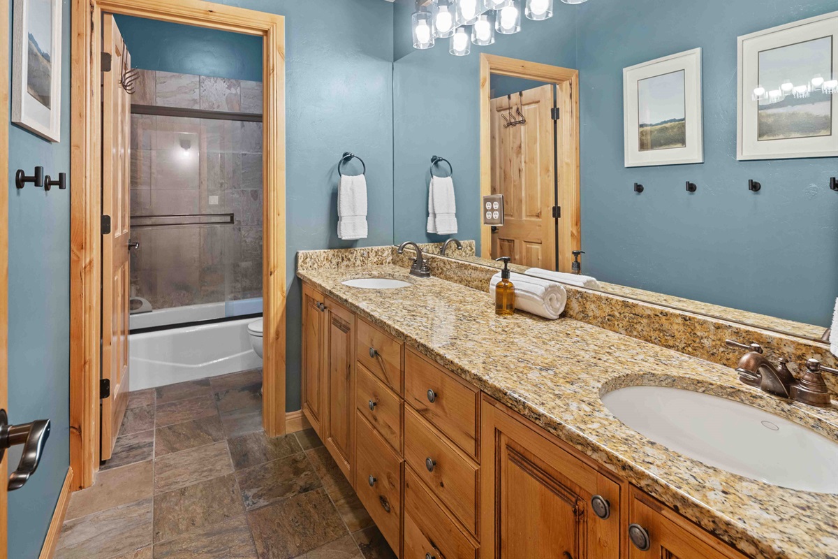 Spacious bathroom with granite counters and a tub/shower combo.
