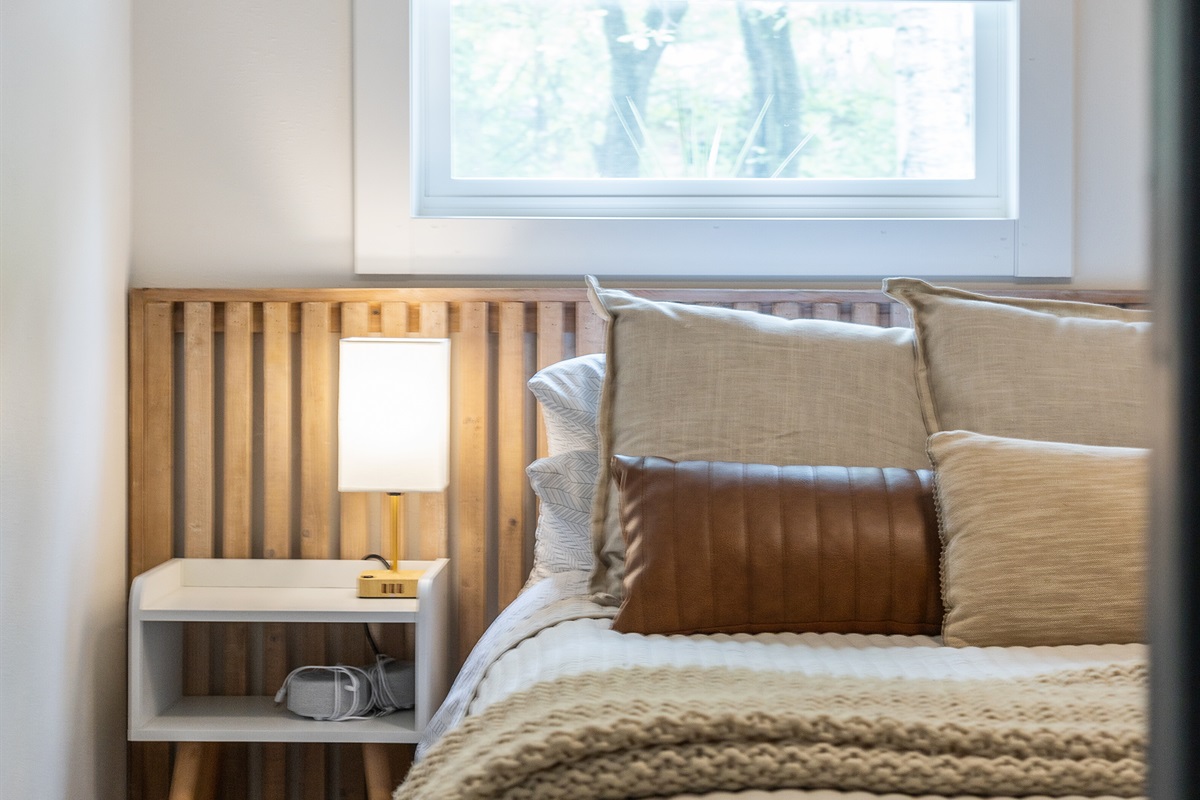 Settle into the cozy queen bed and unwind with the warm glow of bedside lamps perfect for evening reading.