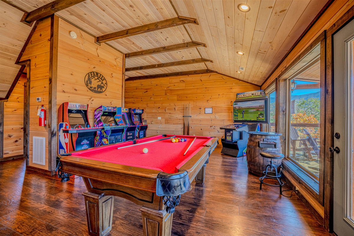 Top-floor game room with arcades, pool table, lounge space, and mountain views.
