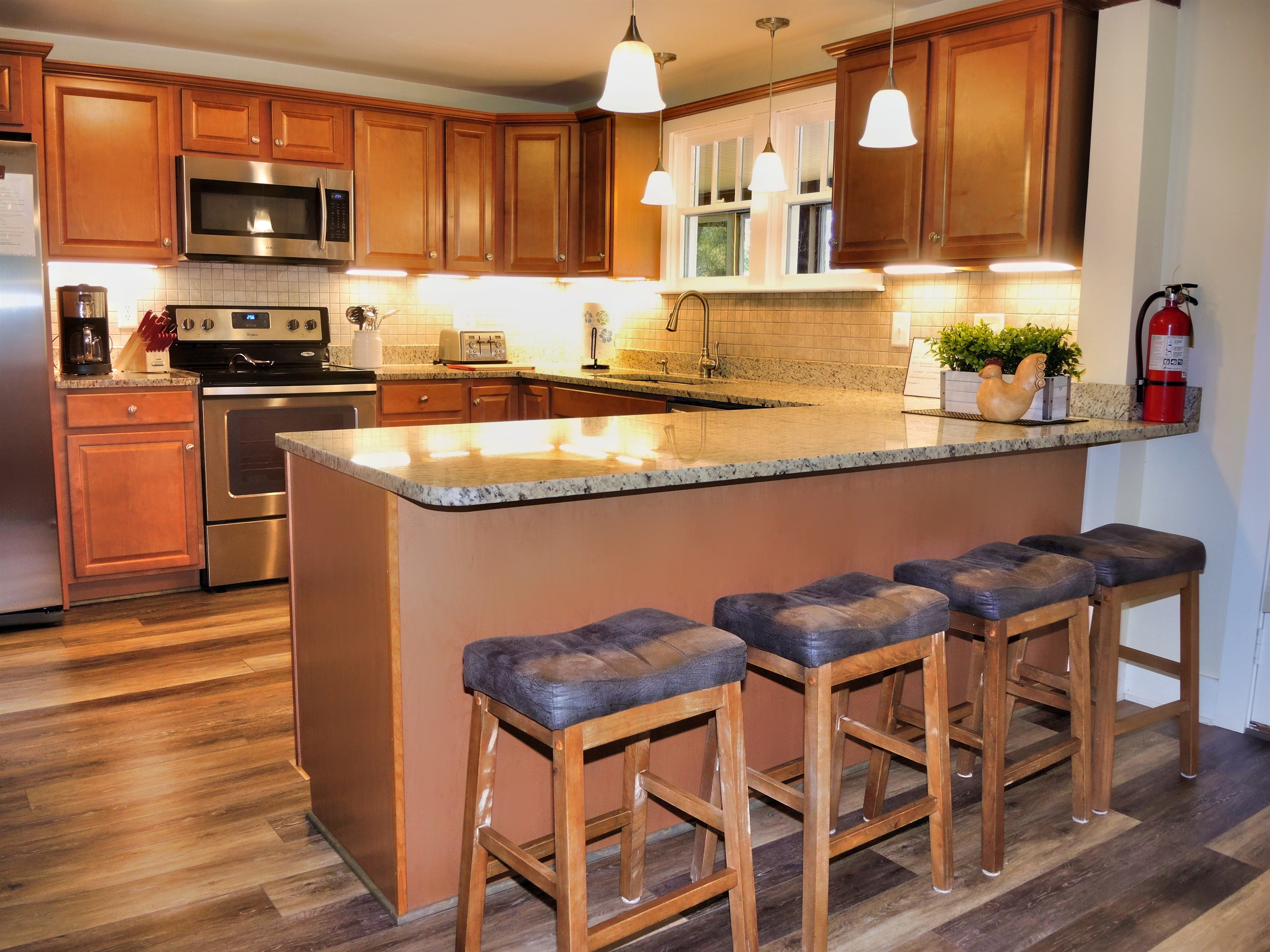 Newly renovated kitchen with granite countertops and breakfast bar seating.