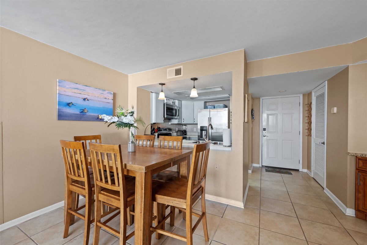 Bright dining space with seating for six, coastal d&eacute;cor, and a convenient pass-through to the fully equipped kitchen